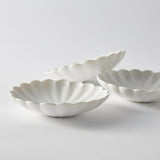 White scalloped flower-shaped serving plate, shallow rim