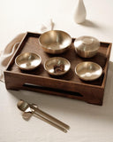 Wooden cutlery rest tray with brushed bronze bowls and utensils