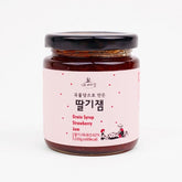 Strawberry fruit jam jar with dark red jam and black lid