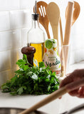 Vegetable umami seasoning sauce bottle with herbs and cooking utensils