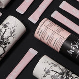 Plum extract sachets and pouches with blossom graphics and printed directions