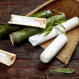 Bamboo salt sticks and paper-wrapped salt pieces on a woven mat