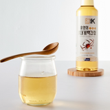 Soy sauce bottle with amber liquid on a wooden coaster, with a glass pouring jar