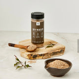 Roasted sprouted sesame seeds jar with wooden spoon and bowl of sesame seeds