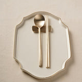 Bronze spoon and chopsticks on a decorative white plate