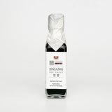 Aged soy sauce bottle with black liquid and white label, sealed in crinkled wrap