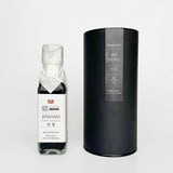 Soy sauce bottle with black gift canister labeled Jinjang, dark liquid visible