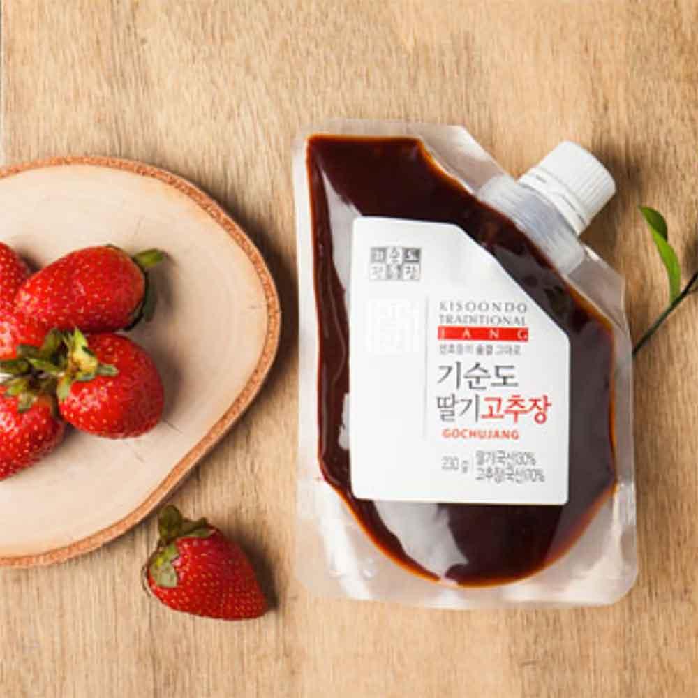 Kisoondo Strawberry gochujang pouch with dark red sauce, with strawberries