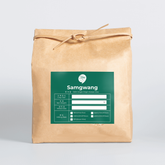 Kraft paper rice bag with green label, tied with twine and a handle.