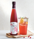 Omija extract bottle and glass drink with orange-red beverage on tray