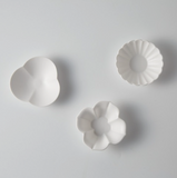 Tiny flower-shaped sauce dishes, three white pieces