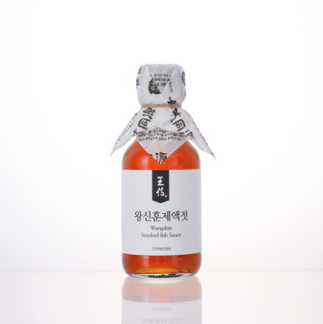 Smoked fish sauce bottle with wrapped cap and front label, amber liquid.