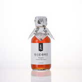 Smoked fish sauce bottle with white label and sealed paper wrap