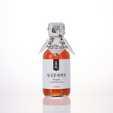 Smoked fish sauce bottle with wrapped cap and front label, amber liquid.
