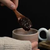 Bellflower extract spoonful, thick dark paste above cup