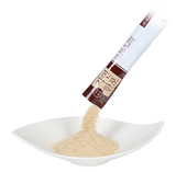 Seafood stock powder stick, single sachet pouring pale beige powder into bowl
