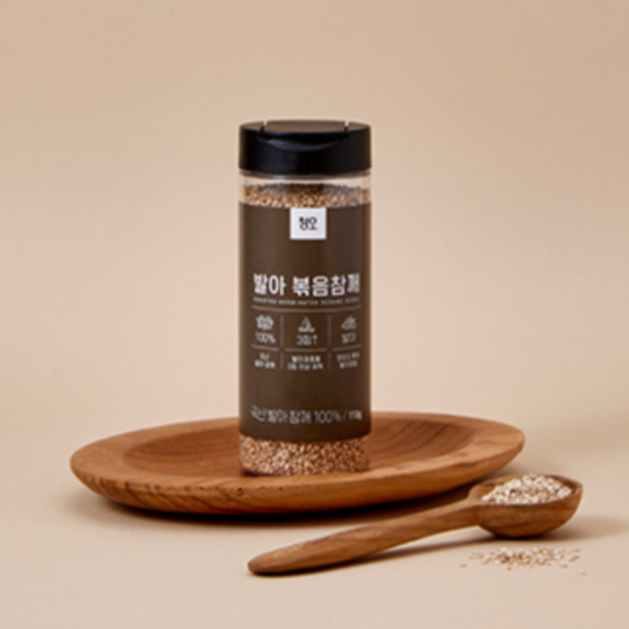 Roasted sprouted sesame seeds jar with black lid on a wooden plate