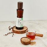 Sesame oil bottle with amber glass and white label beside small bowl and jar