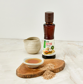 Extra virgin sprouted sesame oil bottle with amber liquid and paper label