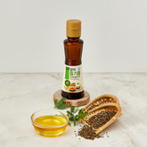 Extra virgin sprouted perilla oil bottle with a small glass of golden oil