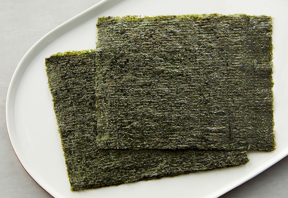 Roasted gimbap laver sheets on a plate, dark green, square pieces