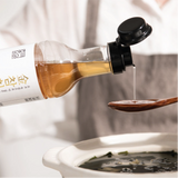 Tuna extract bottle pouring amber liquid into spoon