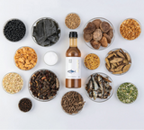 Tuna extract bottle with bowls of dried herbs and seeds