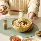 Bowls of clam rice kalguksu noodles with chopsticks and toppings