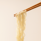 Clam rice kalguksu noodles held up by wooden chopsticks