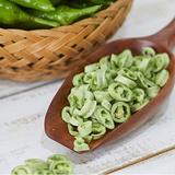 Sliced green chili peppers in a wooden spoon, ringed pieces