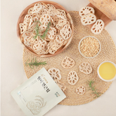 Crispy brown rice lotus root chips in bowl with lotus root slices and seasoning cup