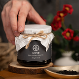 Bellflower extract jar held in hand with cloth-tied lid