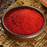 Coarse gochugaru red chili powder in a round bowl on woven material
