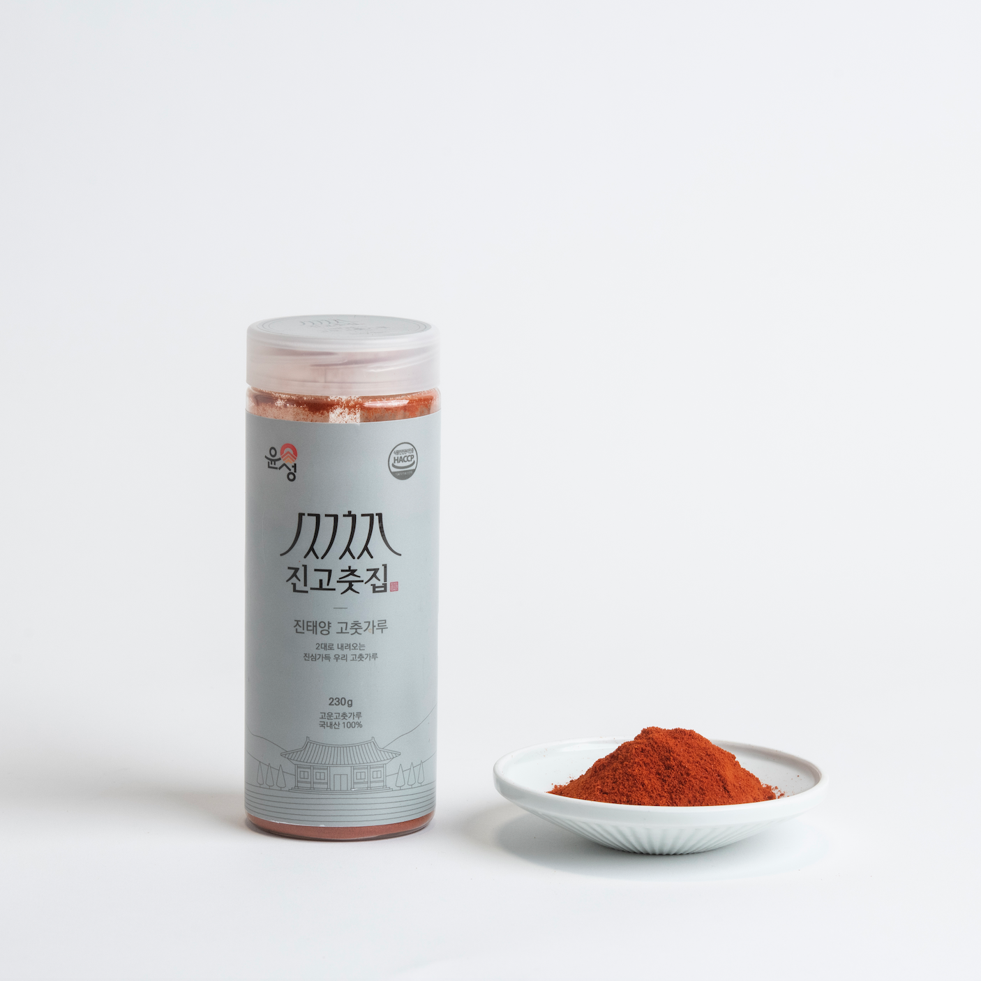 Gochugaru spice jar with ground red chili powder in a small dish