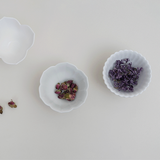 Set of three white tiny flower bowls with scalloped petal rims, shown filled with flowers