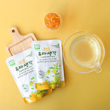 Organic yuzu juice pouches with a small cup of juice, flat lay