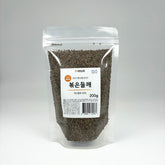 Roasted perilla seeds in a clear stand-up pouch, dark gray-green whole seeds