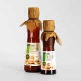 Sprouted perilla oil bottles with paper-wrapped caps and amber liquid