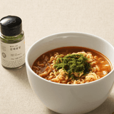 Powder jar and bowl of green soup with leafy garnish