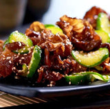Chopped tree-ear mushrooms in a cooked dish with green slices