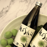 Organic Korean plum extract bottles with MeShil labels, shown with green apples