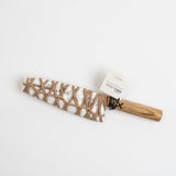 Wrapped chef's knife with wooden handle, twine wrap, and paper tag.