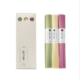 Three-colored noodle set in paper wrap; bundles of green, yellow, and pink noodles