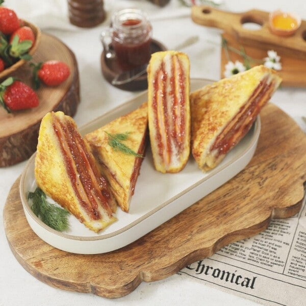 Jam-filled toast sandwiches on a wooden serving board