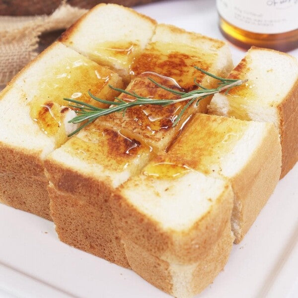 Fruit jam spread on sliced bread with herbs