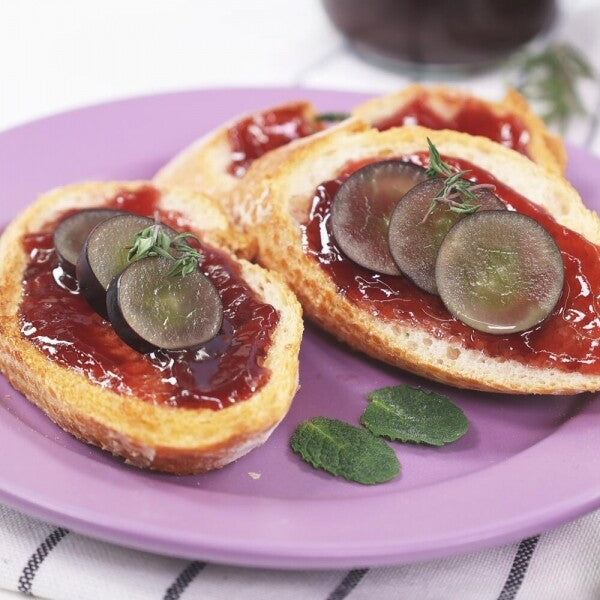 Toast slices with glossy dark red jam and thin radish slices