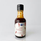 Mild buldak sauce bottle with dark brown sauce, black cap, red-and-white label