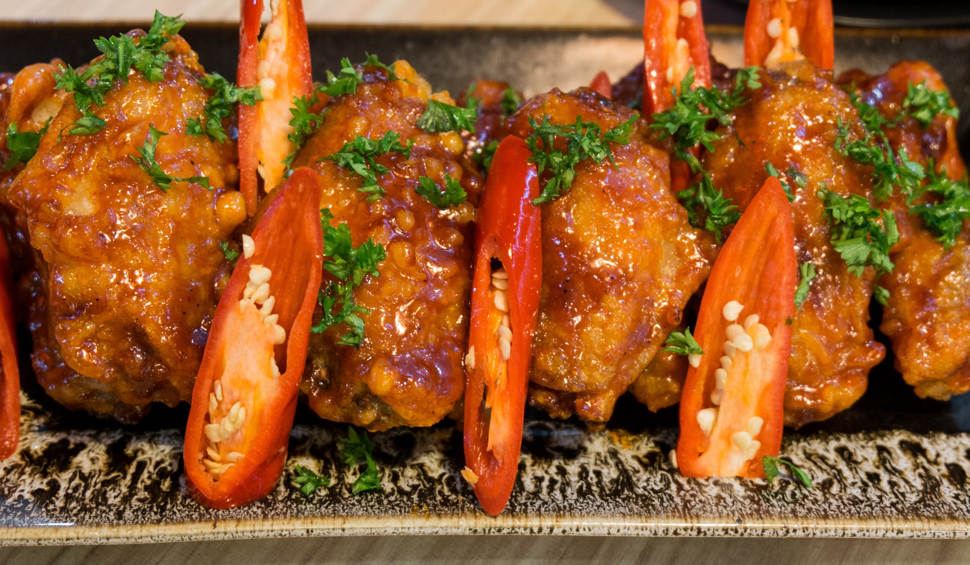 Grilled spicy chicken and shrimp platter with herbs on a hot stone surface