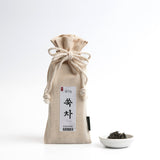 Organic mugwort tea pouch with drawstring and bowl of dried tea leaves