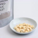 Freeze-dried chopped garlic pouch with bowl of garlic tablets